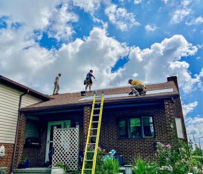 Team members on the roof of an old home. 